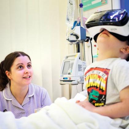 A young patient with a play specialist tries virtual reality glasses