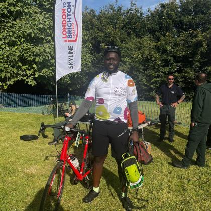 London to Brighton cyclist, Brian, smiling with his bike at the London to Brighton Cycle Ride 2024