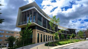 An external view of the front of the Oak Cancer Centre. It's a bright sunny day and there is bright green foliage around the outside of the building.