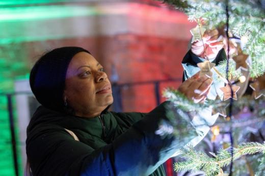 A woman looks for a star on the Christmas tree at the Celebrate a Life carol service