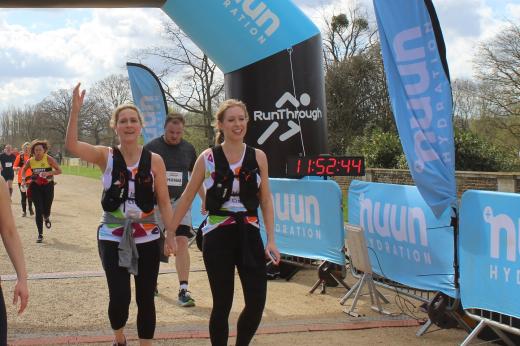 Two runners cross the finish line at the Palace Half Marathon 2024