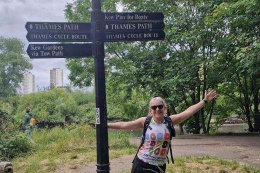 Walker smiling with Thames Path route signs