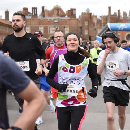 A Team Marsden runner smiles at the camera whilst running the Hampton Court Palace Half Marathon
