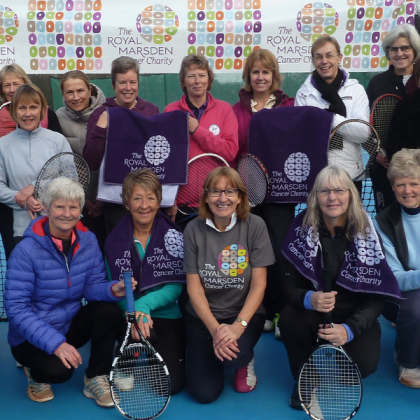 A group of tennis players holding up their rackets and Royal Marsden Cancer Charity-branded towels