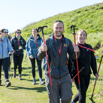 A group of trekkers smiling, walking in the sunshine