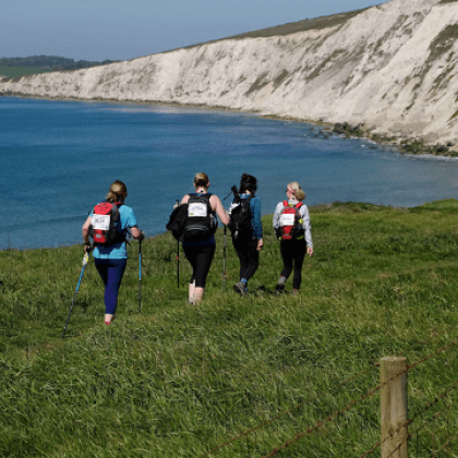 Four walkers walking towards a coastline