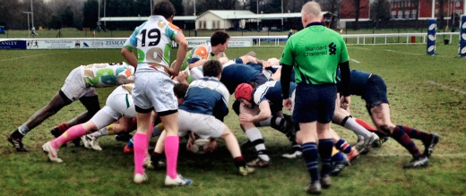 Rugby club charity match players in a scrum
