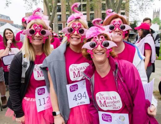 A group of four ladies in pink Banham Marsden March shirts and tutus wearing pink flamingo sunglasses