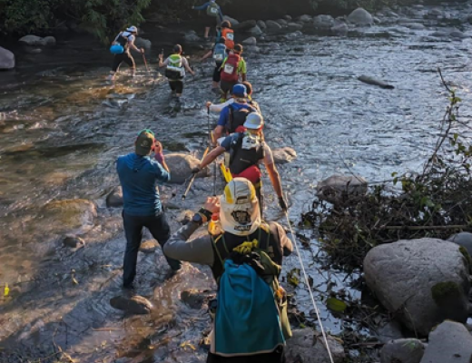 Participants crossing river in Amazon jungle
