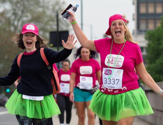 Two women on The Banham Marsden March wearing bright charity t-shirts and green tutus