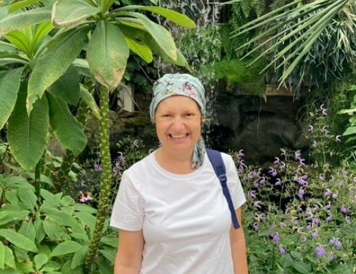 Rebecca Gallagher stands in front of vegetation, smiling.