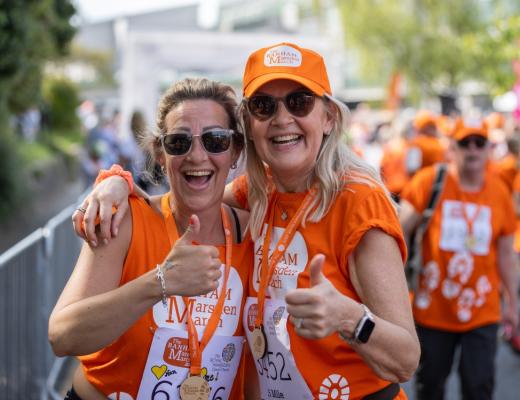 Two women smiling and giving a thumbs up at The Banham Marsden March finish line in Sutton