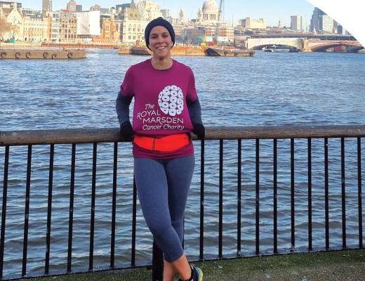 A Jog 40 miles supporter wearing running gear and standing in front of a view across the River Thames and city of London