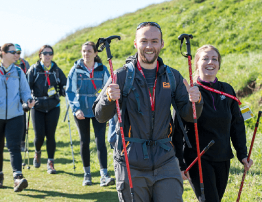 A group of trekkers smiling, walking in the sunshine