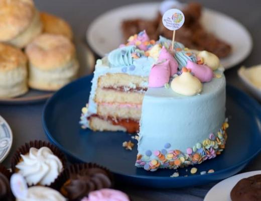 A table top of cakes at a cake sale